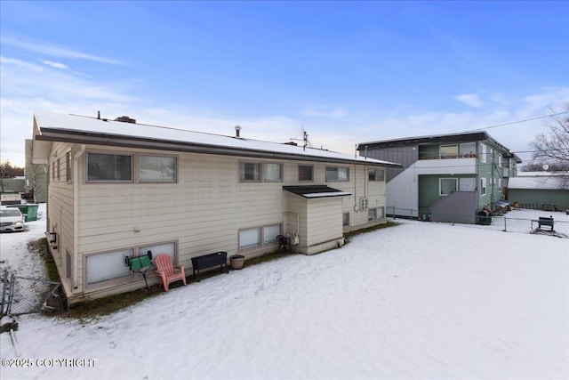 view of snow covered back of property