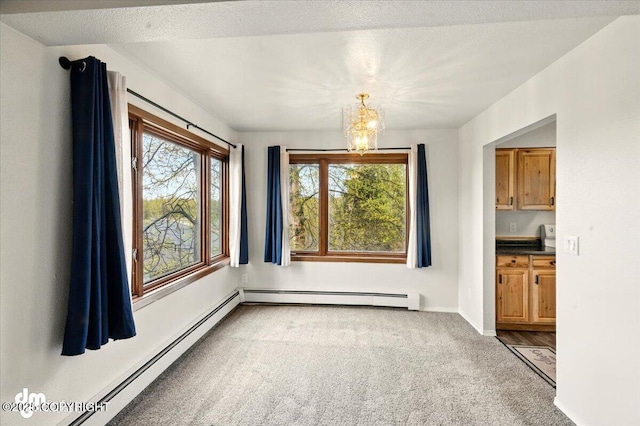 unfurnished room with a chandelier, carpet, baseboard heating, and baseboards
