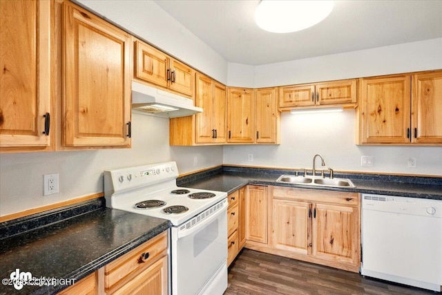 kitchen with white appliances, under cabinet range hood, a sink, and dark countertops