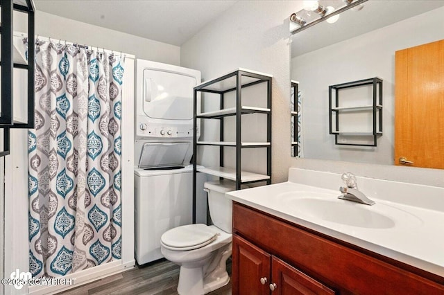 bathroom with stacked washing machine and dryer, wood finished floors, toilet, vanity, and a shower with curtain