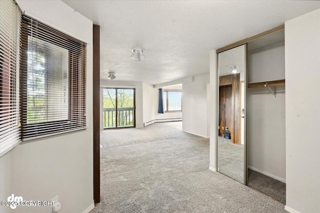 unfurnished bedroom featuring carpet flooring, a baseboard radiator, a closet, a textured ceiling, and baseboards