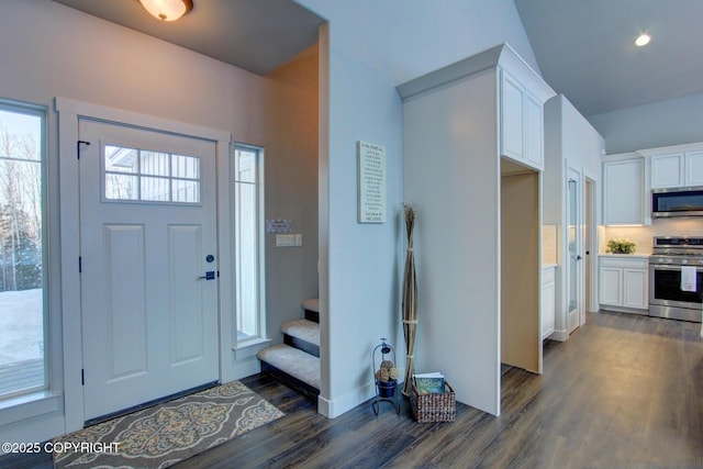 foyer entrance with dark hardwood / wood-style flooring and vaulted ceiling