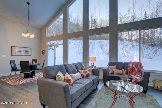 living room featuring a chandelier, a high ceiling, and wood-type flooring