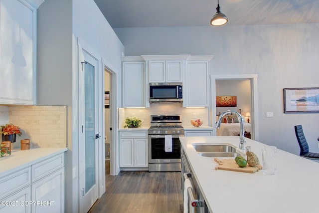 kitchen featuring sink, white cabinets, pendant lighting, and appliances with stainless steel finishes