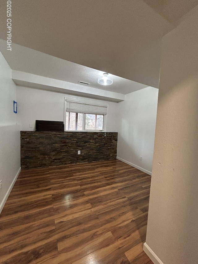 empty room featuring baseboards, visible vents, and wood finished floors