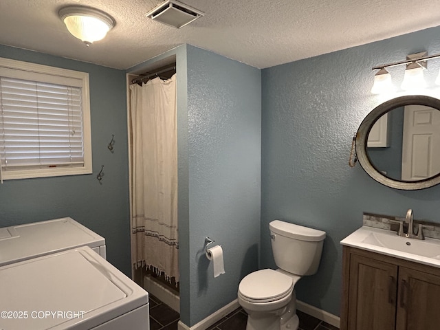 bathroom featuring baseboards, visible vents, toilet, a textured ceiling, and washer and dryer