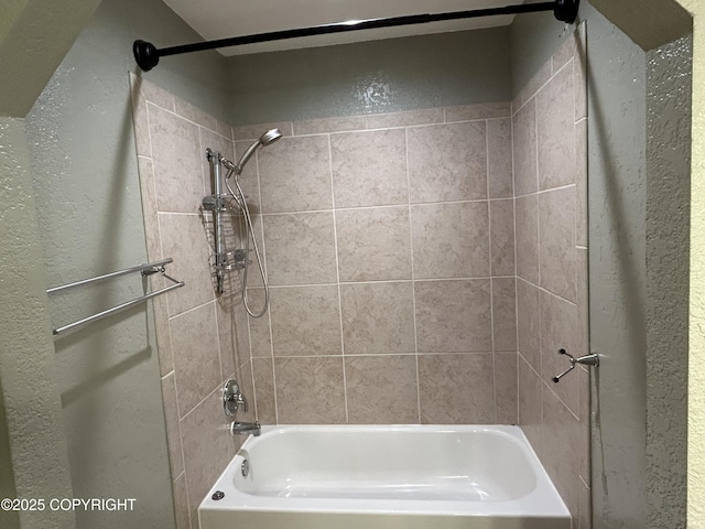 bathroom featuring a textured wall and shower / bathing tub combination