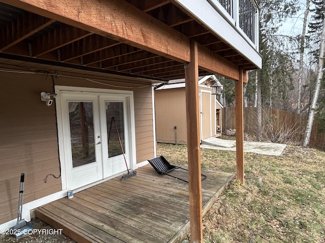 deck with fence, a storage unit, french doors, and an outdoor structure