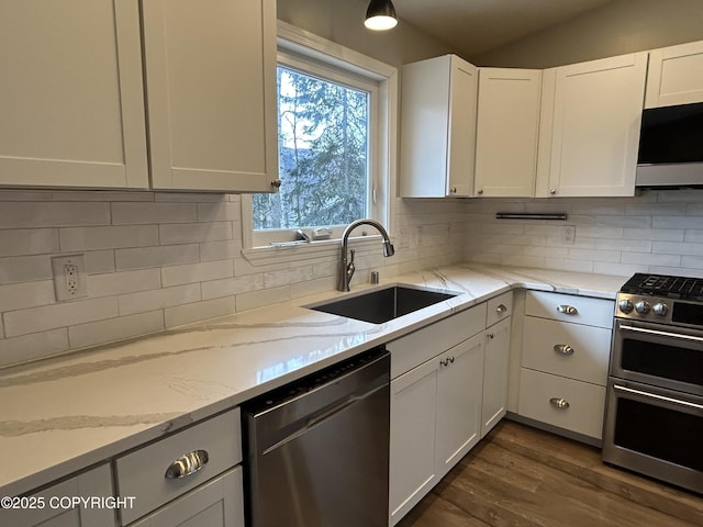 kitchen featuring white cabinets, tasteful backsplash, stainless steel appliances, and a sink