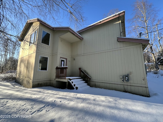 view of snow covered rear of property