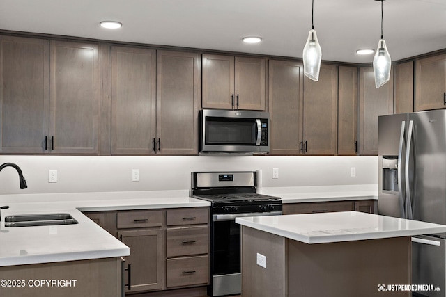 kitchen with decorative light fixtures, a center island, sink, dark brown cabinetry, and stainless steel appliances