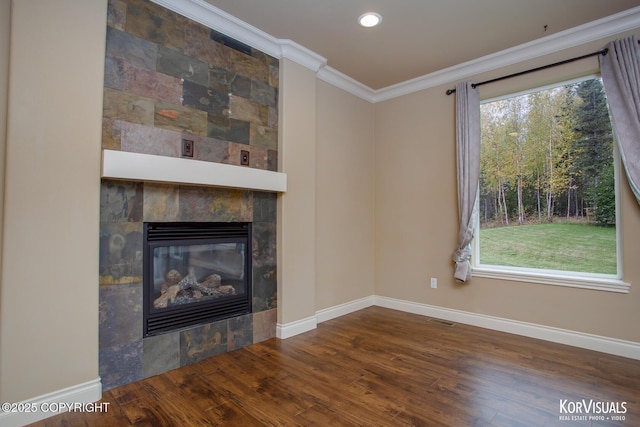 unfurnished living room featuring a tile fireplace, hardwood / wood-style flooring, plenty of natural light, and crown molding