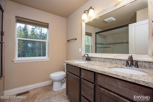 bathroom featuring tile patterned floors, vanity, toilet, and walk in shower