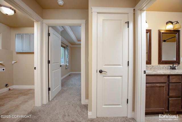 corridor with sink and light colored carpet