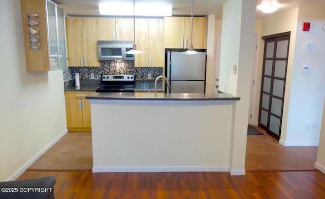 kitchen with backsplash, dark stone counters, stainless steel appliances, light brown cabinets, and dark tile patterned flooring