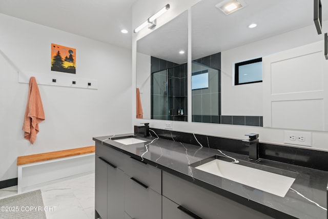 bathroom featuring a shower with door and vanity