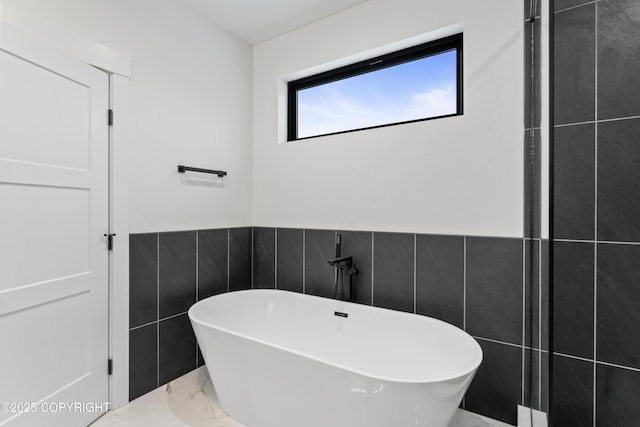 bathroom featuring a bathing tub and tile walls