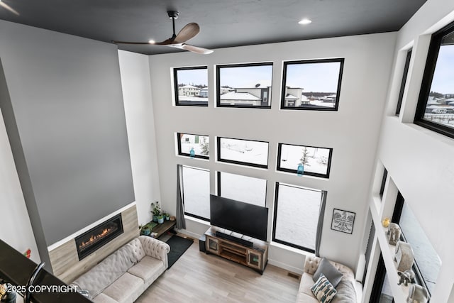 living room with ceiling fan and light hardwood / wood-style flooring