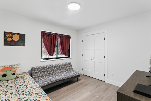 bedroom with light hardwood / wood-style floors and a closet