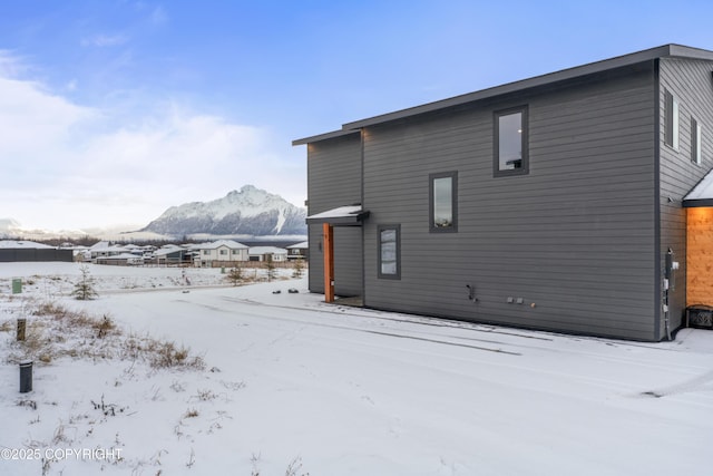 snow covered rear of property with a mountain view