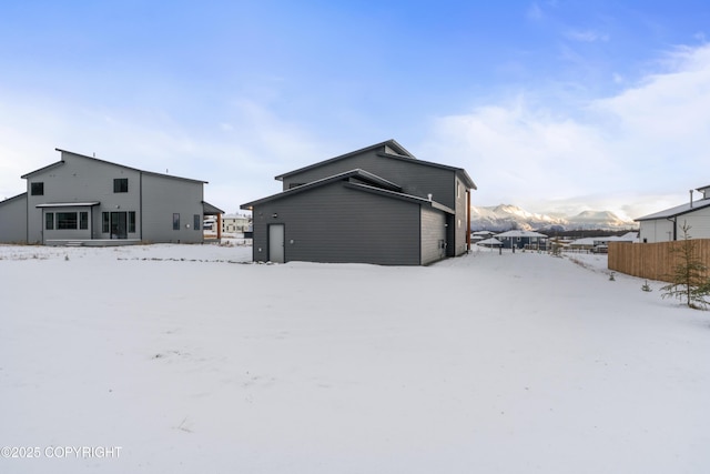 snow covered house featuring a mountain view and a garage