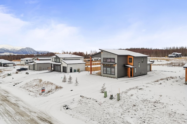 snow covered back of property with a mountain view