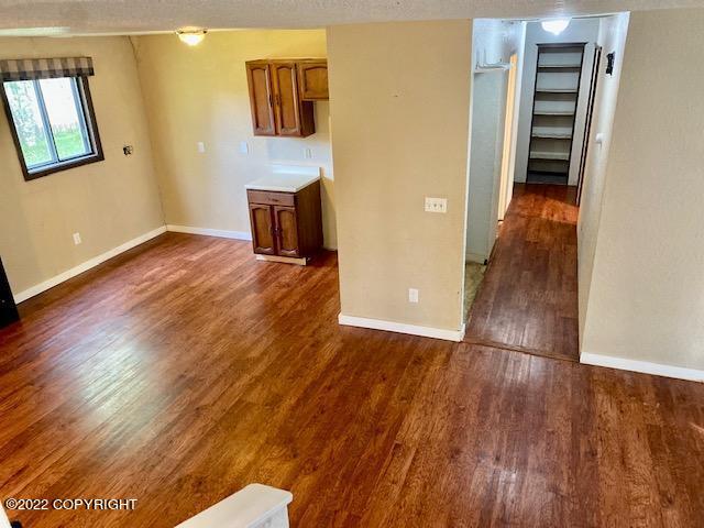 interior space with a textured ceiling and dark hardwood / wood-style flooring