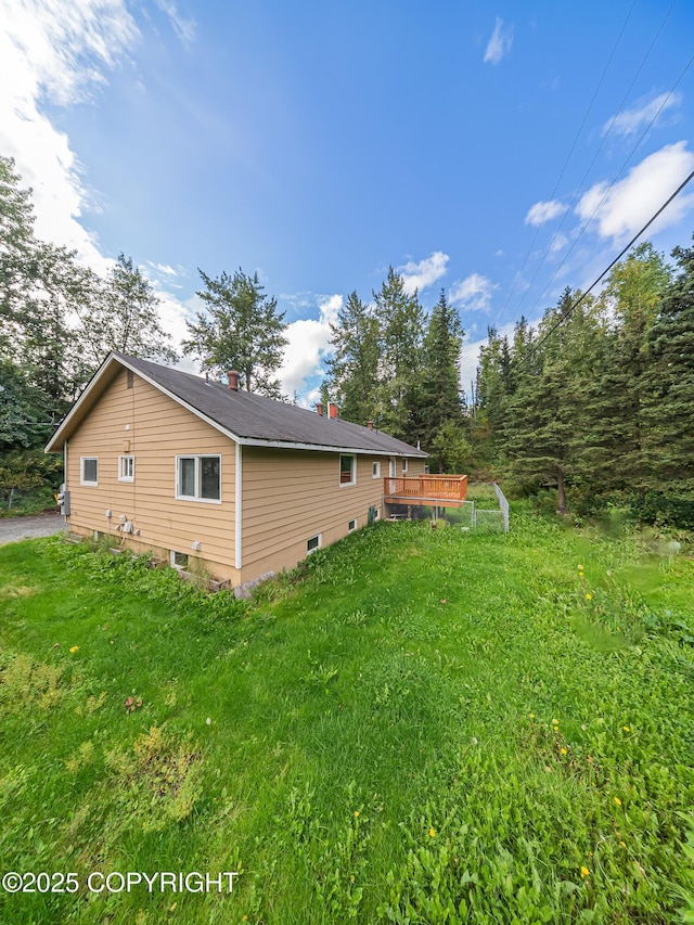 view of side of home featuring a deck and a lawn