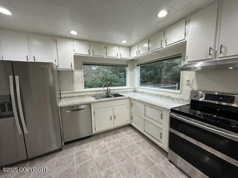 kitchen featuring sink, white cabinetry, stainless steel appliances, and tasteful backsplash