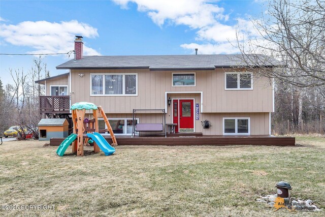5450 E Alder Dr, Wasilla, AK 99654 - view of front facade featuring a front lawn, a deck, a chimney, a shingled roof, and a playground