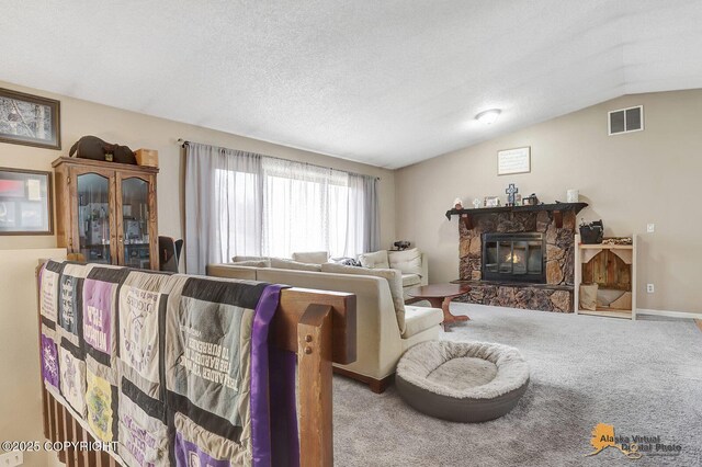 5450 E Alder Dr, Wasilla, AK 99654 - carpeted living room featuring visible vents, a stone fireplace, and vaulted ceiling