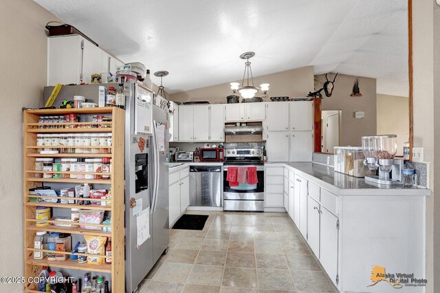 5450 E Alder Dr, Wasilla, AK 99654 - kitchen featuring decorative light fixtures, vaulted ceiling, a chandelier, stainless steel appliances, and white cabinetry