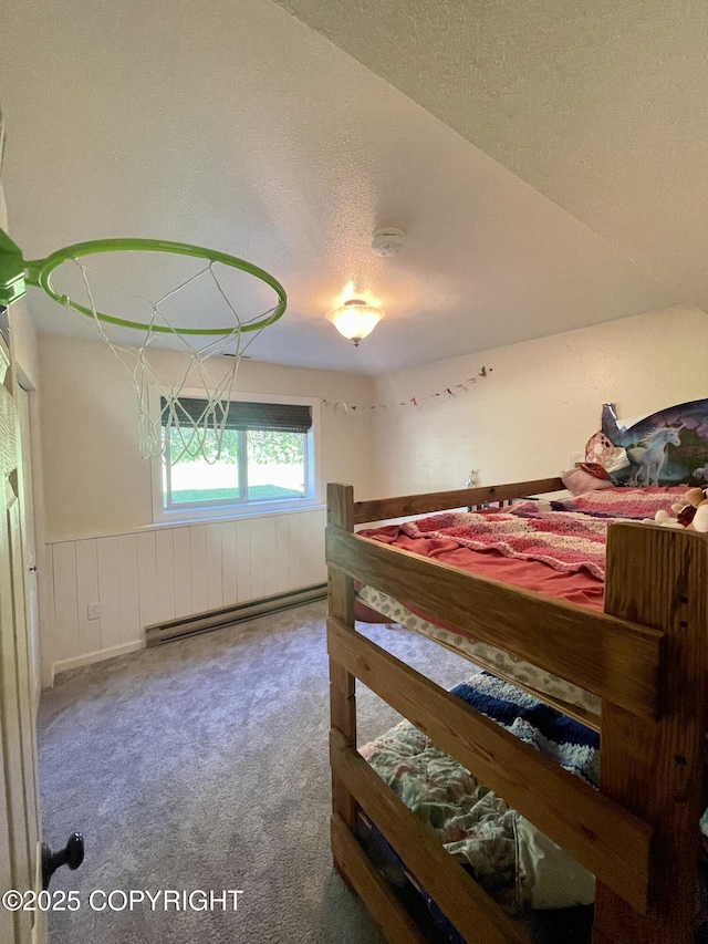 bedroom with a baseboard heating unit, a textured ceiling, and carpet flooring