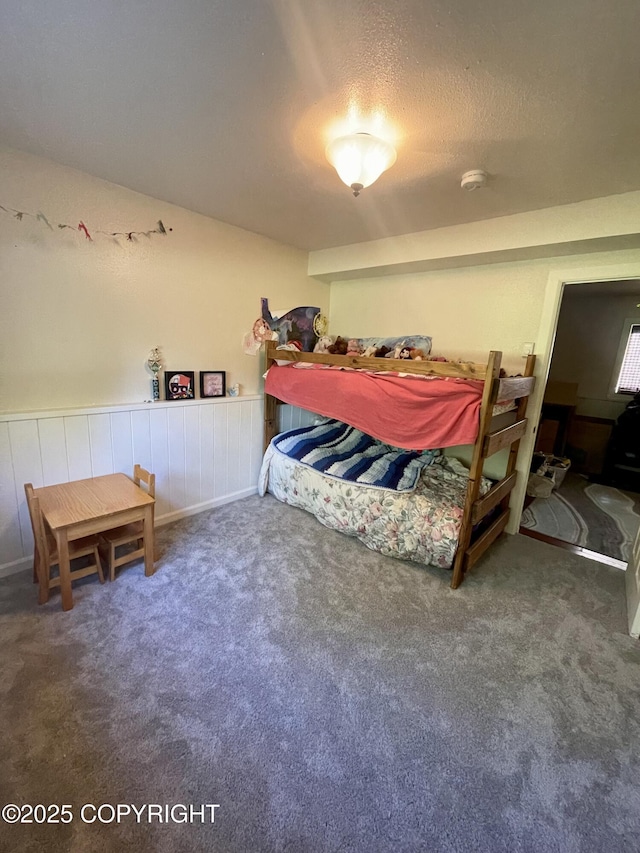 bedroom featuring a textured ceiling and dark colored carpet