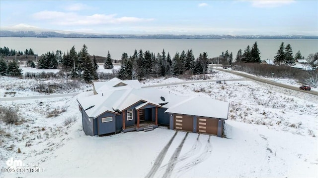 snowy aerial view featuring a water view