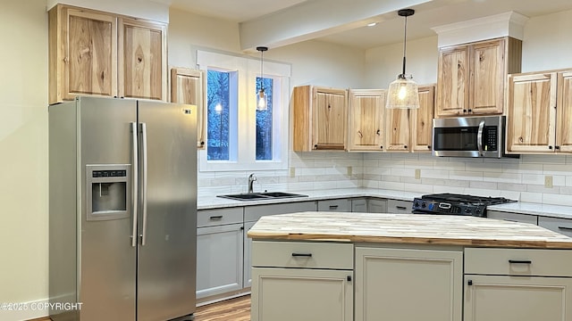 kitchen featuring butcher block countertops, a kitchen island, stainless steel appliances, and pendant lighting