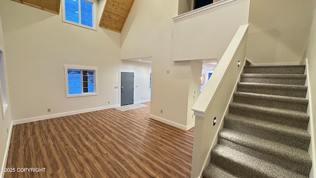 stairs with wood ceiling, hardwood / wood-style flooring, and high vaulted ceiling