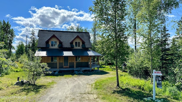 9742 W Trimotor St, Wasilla, AK 99623 - view of front of property with covered porch, dirt driveway, and roof with shingles