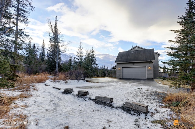 snowy yard featuring a garage