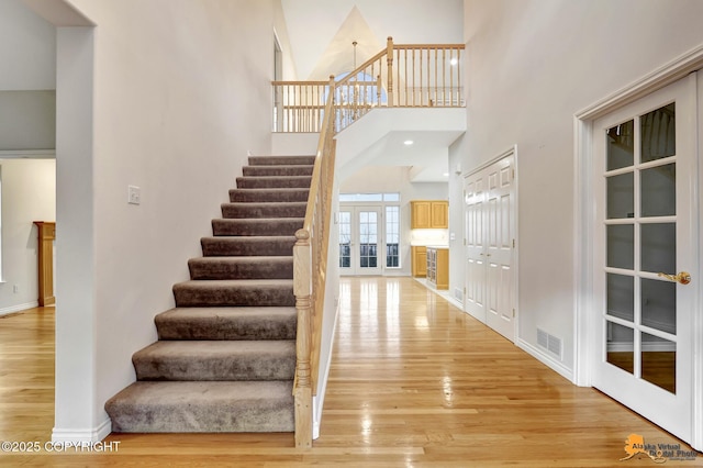 entrance foyer with wood-type flooring and a towering ceiling