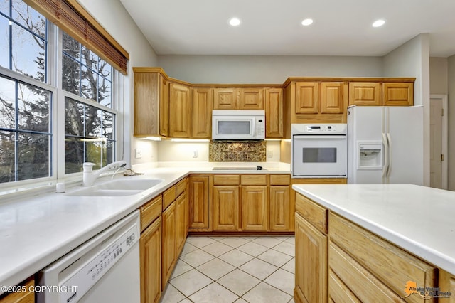 kitchen with sink, backsplash, white appliances, and light tile patterned flooring