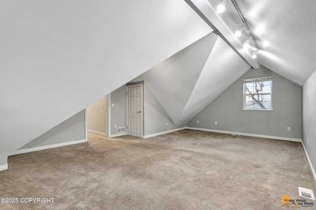 additional living space featuring vaulted ceiling and carpet flooring