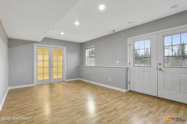 foyer with light wood-type flooring and french doors