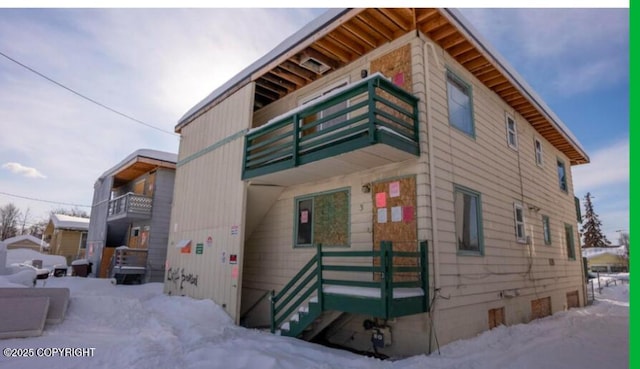 view of snowy exterior featuring a balcony