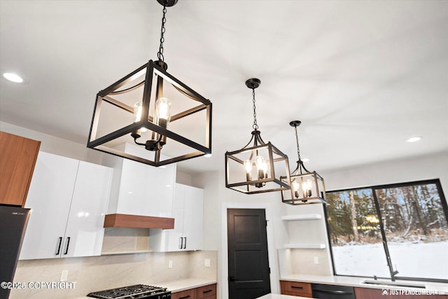 kitchen with decorative backsplash, decorative light fixtures, white cabinets, and black dishwasher