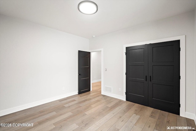 unfurnished bedroom featuring a closet and light hardwood / wood-style flooring