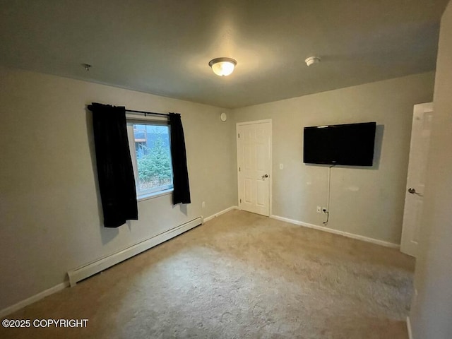 spare room featuring light colored carpet and baseboard heating