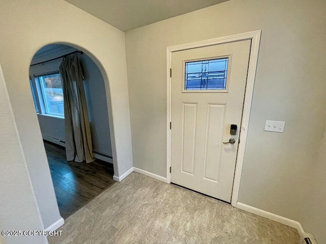 foyer entrance featuring baseboard heating and light hardwood / wood-style flooring