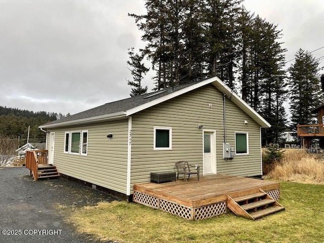 rear view of house with a lawn and a deck