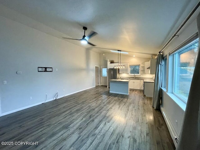 kitchen featuring white cabinetry, a center island, vaulted ceiling, hanging light fixtures, and dark hardwood / wood-style flooring